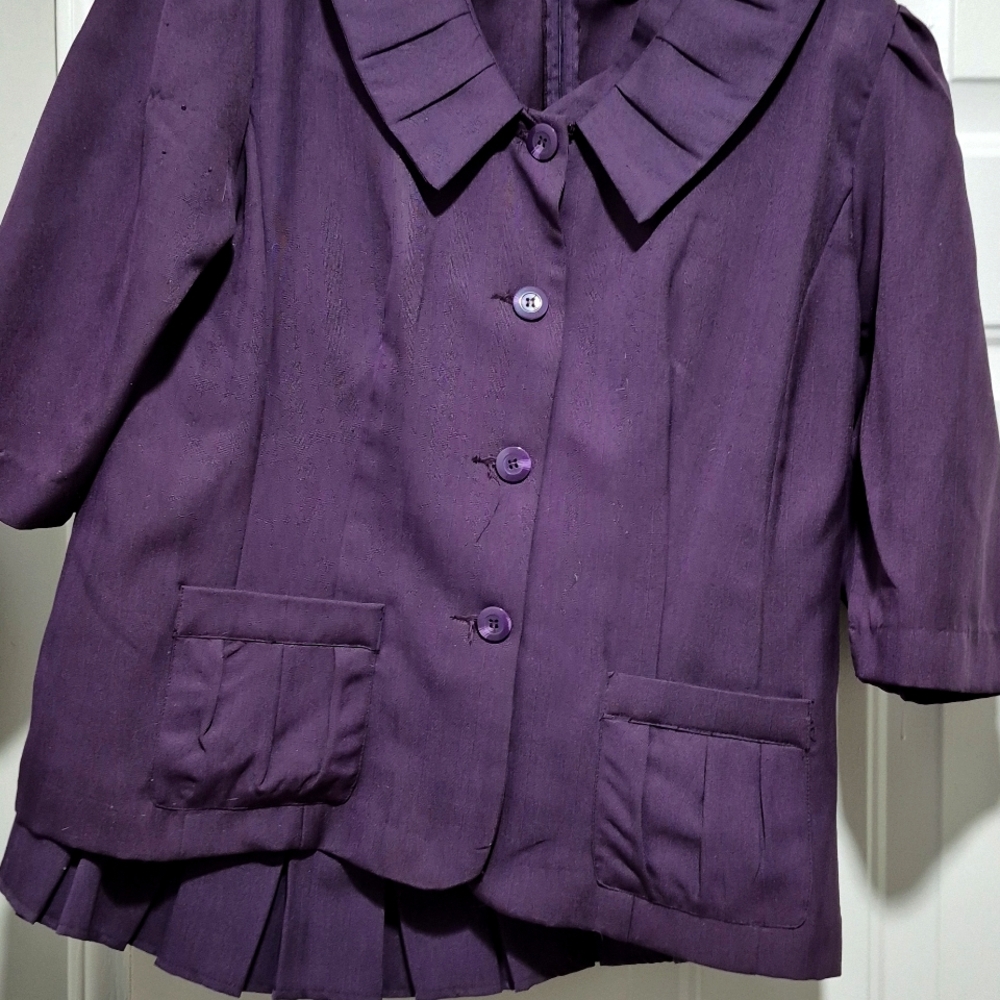 Eggplant purple suit w front pockets. Buttons up  front. Skirt has no pockets.